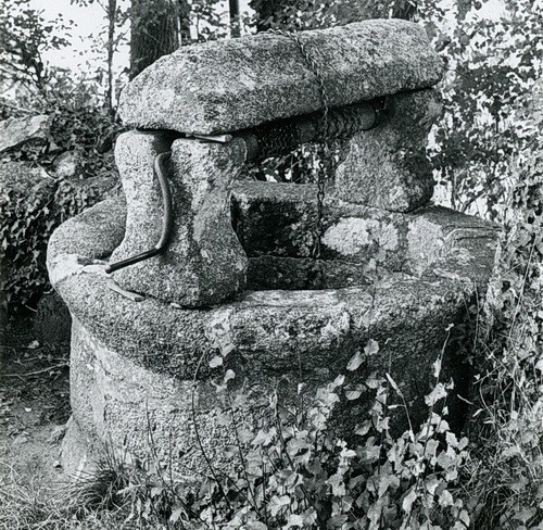 Puits de Stang Quelfen. Linteau pentagonal daté de 1677. Margelle débordante, poteau galbé.