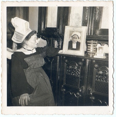 Phine-Janny chez elle devant la photo de sa mère Jeanny (tableau d’Édouard Martin)